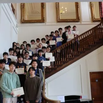 Students on the school's staircase with their physics bowl certificates